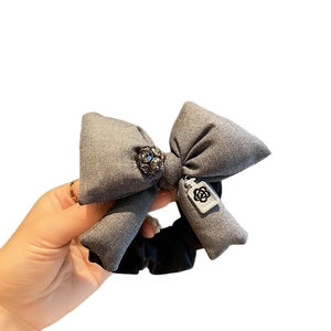 Elegant grey fabric bow scrunchie with rhinestones and silver perfume pendant detail