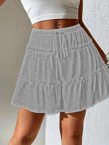 Detail of the high-waisted drawstring and layered ruffle design on this grey tiered skirt