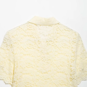 Pale yellow lace short sleeve polo shirt for women featuring delicate floral patterns