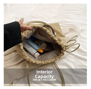 Top view detail of the large capacity beige bucket bag showing interior space and zipper pocket