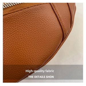 Close-up of tan lychee grain leather texture with premium metal zipper and fine stitching