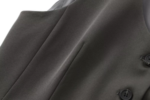 Vue détaillée de la texture du tissu sergé gris foncé avec un bouton noir à quatre trous