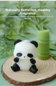 Detailed view of handmade panda scented candle on wood base with bamboo accent