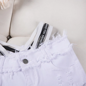 Dettaglio di pantaloncini di denim bianchi con frange e elastico in vita con logo