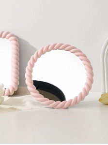 Close-up of pink twisted-frame tabletop makeup mirrors with a circular and rectangular design