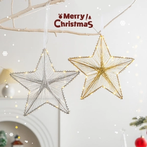Stelle di Natale luminose oro e argento con luci LED appese su un ramo decorato