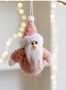 Detail of pink fleece Santa Claus ornament with wood buttons and festive warm lighting