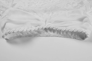 Detail of white lace stitching and ruched mesh texture on a sexy bodycon dress