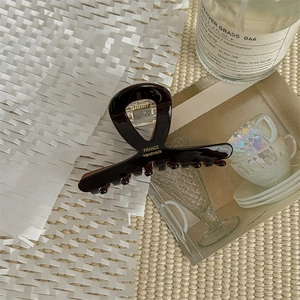 Detail van de bruine acetaat haarklem met France Handmade tekst gegraveerd