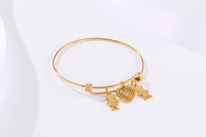 Detail of adjustable gold titanium bracelet with heart and family silhouette charms