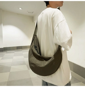 Détail du sac bandoulière en nylon vert armée montrant le tissu durable et le style épuré