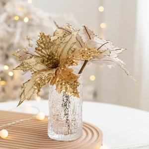 Golden artificial Christmas flower with sequins in glass vase on a wooden tray