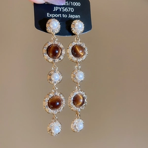 Detail of tassel earrings featuring tiger eye stones, pearls, and S925 silver needles