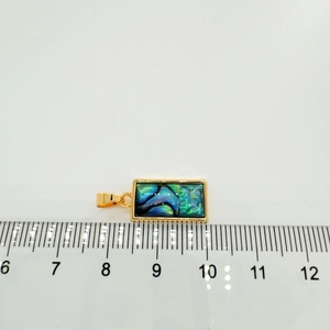 Detailed view of the abalone shell pendant with a ruler showing its 1.5cm length