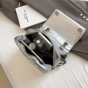 Quilted silver chain bag with spacious interior shown on a minimal aesthetic background