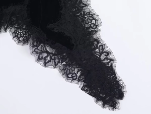 Nahaufnahme der eleganten schwarzen Wimpernspitze und Samttextur auf einem Abendkleid