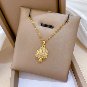 Detailed view of a gold mushroom necklace with sparkling crystals in a jewelry box