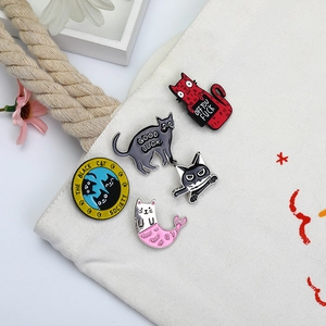 Zinc alloy cat enamel pins set featuring creative designs displayed on a canvas bag