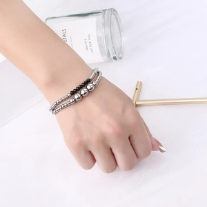 Close-up of double-layer beaded bracelet with silver metal and black faceted crystals