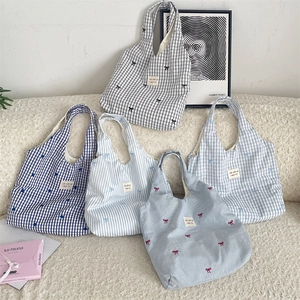Détails de broderie et motifs chic sur un groupe de sacs shopping minimalistes en toile