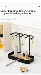 Detail of jewelry organizer featuring black matte metal hooks and a wooden base tray