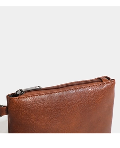 Detailed macro shot of brown lychee-patterned PU leather and premium metal zipper
