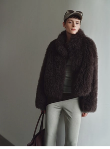 Detail view of dark brown plush faux fur vest with a high stand collar and soft texture