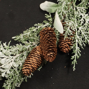 Frosted pine needle and pine cone branch decoration with artificial snow for Christmas