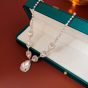 Vue détaillée du pendentif goutte argenté avec zircons sertis dans son écrin vert chic