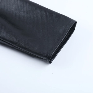 Close-up of the detailed fine texture and stitching on the black faux leather jacket sleeve