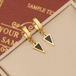 Modern gold geometric hoop earrings with black enamel triangles on a luxury display box