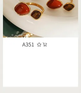 Detail of vintage gold-plated titanium steel rings with red and brown resin gemstones
