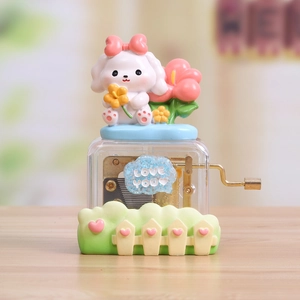 Hand-cranked music box with white dog figurine, pink bow and gold mechanical movement
