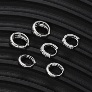 Detail of three-piece silver hoop earring set with polished finish and cubic zirconia inlay