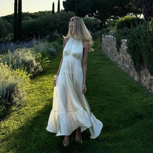 Elegant white polka dot halter neck satin dress with ruffled hem in a garden setting