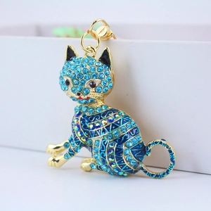 Blue lucky cat keychain with crystal rhinestones and gold accents on white background