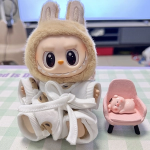Close-up of Labubu doll wearing a white patterned bathrobe with a pink pig figurine
