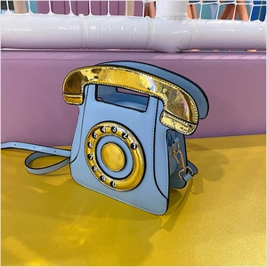 Detail of sky blue retro rotary phone crossbody bag with shiny gold metal hardware