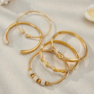 Bracelets dorés à vagues irrégulières et sertis de diamants sur un tissu en lin naturel