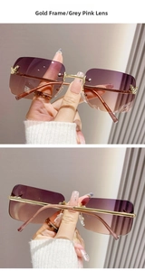 Detail of Y2K rimless sunglasses with butterfly metal accents and grey pink gradient lenses