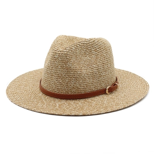 Detailed close-up of woven panama hat texture with dark brown leather strap and gold buckle