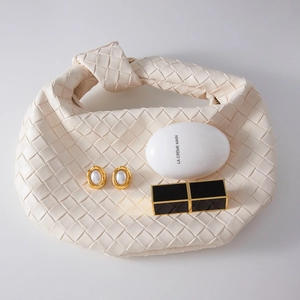 Detailed view of off-white woven hobo bag with signature knot handle and premium texture