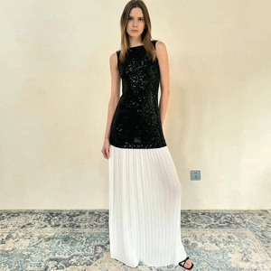 Detail of elegant backless dress with black sequins top and white pleated long skirt