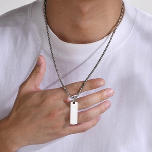 Detailed view of silver rectangular stainless steel pendant on a square link chain