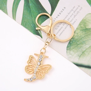 Macro shot of gold butterfly keychain with letter F and sparkling crystal rhinestones