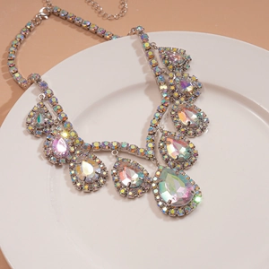 Macro detail of silver layered necklace with teardrop AB rhinestones on white plate