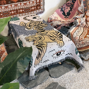 Detail of bohemian outdoor blanket featuring fringed edges and flying tiger pattern