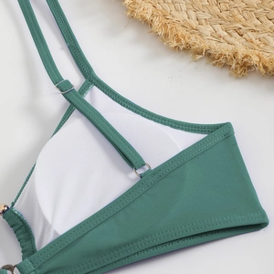 Detail of teal bikini top showing white mesh lining and silver adjustable buckles
