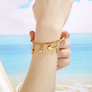 Detailed view of 18K gold plated ocean theme charm bracelet with starfish and shell pendants