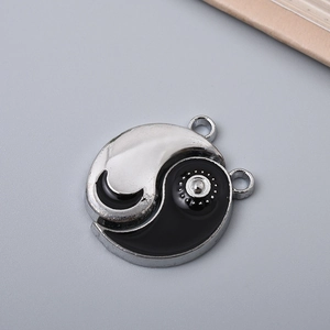 Macro view of metallic Yin Yang Tai Chi pendant charm with dual black and silver segments